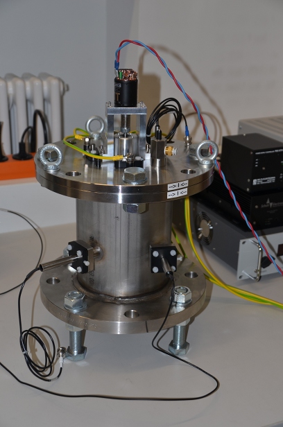 Side view of the experiment Galinstan Tank 1 (GT1). The motor on the top is stirring the liquid in the cylinder. The flow is measured by ultrasonic Doppler velocimetry (UDV probes with black cables). Electrical current can be injected into the fluid via four electrodes (two yellow-green cables)